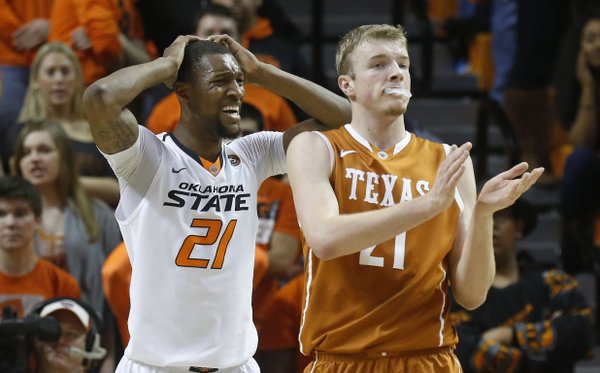 Oklahoma State post Kamari Murphy (21) holds his head and Texas forward Connor Lammert (21) applauds after Murphy was called for a foul during the first half of an NCAA college basketball game in Stillwater, Okla., Wednesday, Jan. 8, 2014. (AP Photo/Sue Ogrocki)