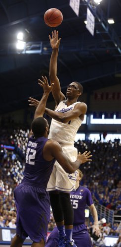 Kansas center Joel Embiid floats a shot high over Kansas State forward Thomas Gipson during the second half on Saturday, Jan. 11, 2014 at Allen Fieldhouse.