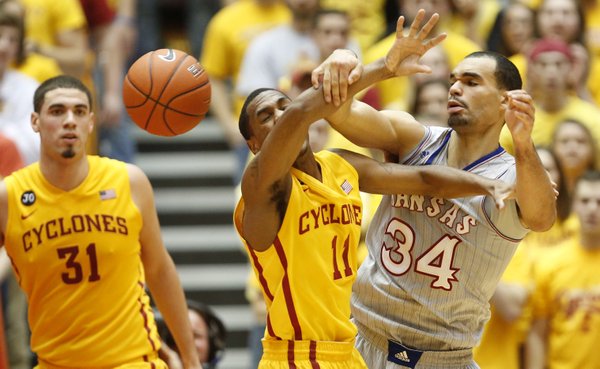 Kansas forward Perry Ellis battles for the ball with Iowa State guard Monte Morris during the first half on Monday, Jan. 13, 2014 at Hilton Coliseum in Ames, Iowa. At left is ISU forward Georges Niang.