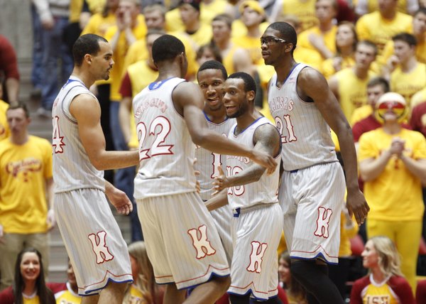 Kansas teammates celebrate a three-pointer by point guard Naadir Tharpe, center against Iowa State during the first half on Monday, Jan. 13, 2014 at Hilton Coliseum in Ames, Iowa.