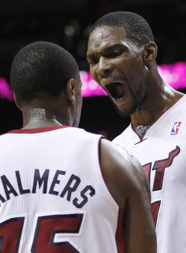 Miami Heat's Chris Bosh, right, yells while talking with Mario Chalmers (15) during the second half of an NBA basketball game against the Cleveland Cavaliers on Tuesday, Jan. 24, 2012, in Miami. The Heat defeated the Cavaliers 92-85. (AP Photo/Lynne Sladky) 