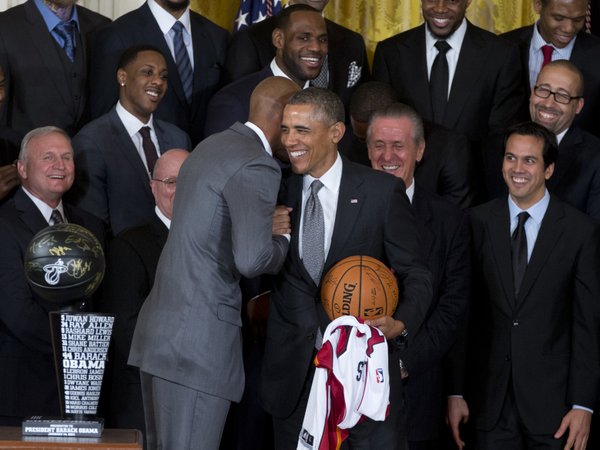President Barack Obama holds a basketball and Miami Heat basketball jersey and shakes hands with Miami Heat player Ray Allen during a ceremony in the East Room of the White House in Washington,, Tuesday, Jan. 14, 2014, where the president honored the 2013 NBA Champion basketball team on their second-straight title. Behind them are Miami Heat forward LeBron James, team president Pat Riley is second from left, Miami Heat head coach Erik Spoelstra is at left. . (AP Photo/Carolyn Kaster) 