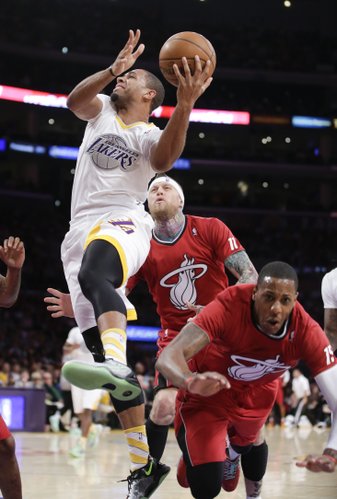 Los Angeles Lakers forward Xavier Henry, left, shoots past Miami Heat's Mario Chalmers, right, and Chris Andersen during the first half of an NBA basketball game in Los Angeles, Wednesday, Dec. 25, 2013. (AP Photo/Chris Carlson) 