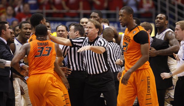 Game officials break up a skirmish between the Kansas and Oklahoma State players during the first half on Saturday, Jan. 18, 2014 at Allen Fieldhouse.
