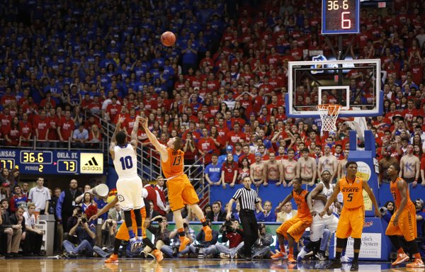 Kansas guard Naadir Tharpe puts up a three over Oklahoma State guard Phil Forte with seconds remaining in the second half on Saturday, Jan. 18, 2014 at Allen Fieldhouse. Tharpe hit the three to widen the Jayhawks' lead.