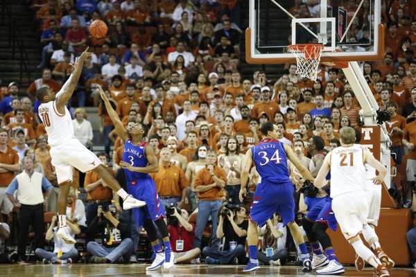 Texas forward Jonathan Holmes turns for a shot over Kansas guard Andrew White during the first half on Saturday, Feb. 1, 2014 at Erwin Center in Austin, Texas.