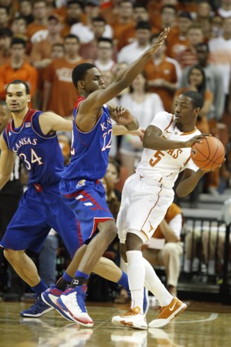 Kansas guard Andrew Wiggins tries to defend a pass from Texas guard Damarcus Croaker during the second half on Saturday, Feb. 1, 2014 at Erwin Center in Austin, Texas. At left is Kansas forward Perry Ellis.