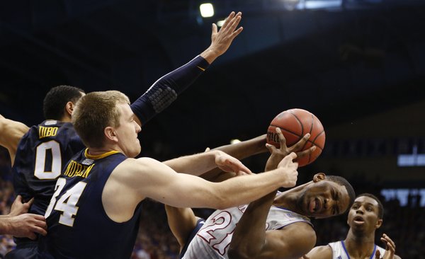 Kansas center Joel Embiid is fouled as he pulls away a rebound from West Virginia forward Kevin Noreen during the second half on Saturday, Feb. 8, 2014 at Allen Fieldhouse.