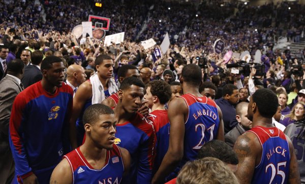 Kansas guard Frank Mason, front, and his teammates look for an exit from the court as the Kansas State student section celebrate following the Jayhawks' 85-82 overtime loss to Kansas State on Monday, Feb. 10, 2014 at Bramlage Coliseum.