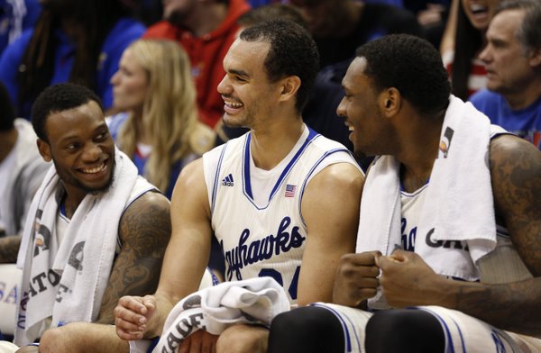 Kansas forward Perry Ellis, center, smiles as he is congratulated by his teammates Naadir Tharpe, left, and Tarik Black after leaving the game following a 32-point effort against TCU  on Saturday, Feb. 15, 2014 at Allen Fieldhouse.