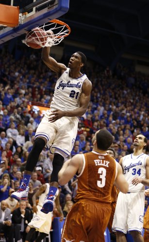 Kansas center Joel Embiid delivers a thunderous dunk before Texas guard Javan Felix during the first half on Saturday, Feb. 22, 2014 at Allen Fieldhouse.