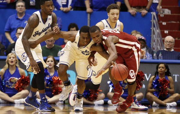 Kansas guard Andrew Wiggins collides with Oklahoma guard Buddy Hield as the two vie for a loose ball during the second half on Monday, Feb. 24, 2014 at Allen Fieldhouse. Also pictured are KU forward Jamari Traylor, left, and guard Brannen Greene.
