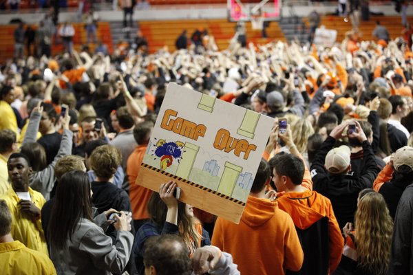 An Oklahoma State fan hoists a sign celebrating the Jayhawks' demise on Saturday, March 1, 2014 at Gallagher-Iba Arena in Stillwater, Oklahoma.