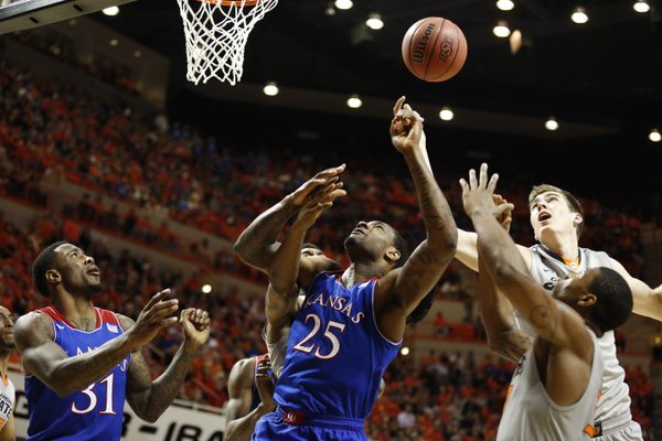 Kansas forward Tarik Black tangles in the paint with Oklahoma State defenders Mason Cox, back right, and Marcus Smart during the second half on Saturday, March 1, 2014 at Gallagher-Iba Arena in Stillwater, Oklahoma.