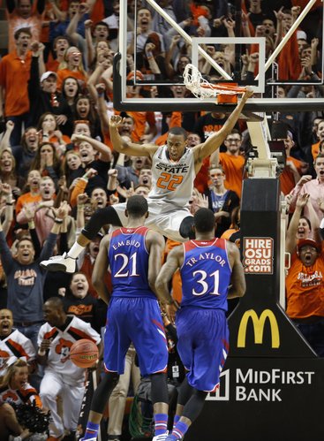 Kansas players Joel Embiid and Jamari Traylor watch as Oklahoma State guard Markel Brown comes down from a dunk during the second half on Saturday, March 1, 2014 at Gallagher-Iba Arena in Stillwater, Oklahoma.