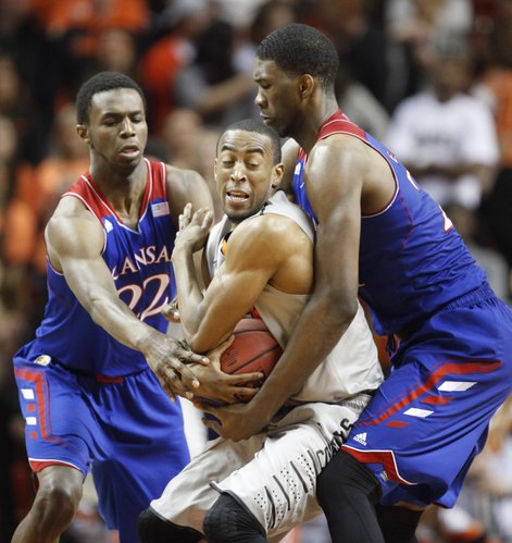 Kansas player Joel Embiid, right, and Andrew Wiggins try to tie up Oklahoma State guard Markel Brown during the second half on Saturday, March 1, 2014 at Gallagher-Iba Arena in Stillwater, Oklahoma.