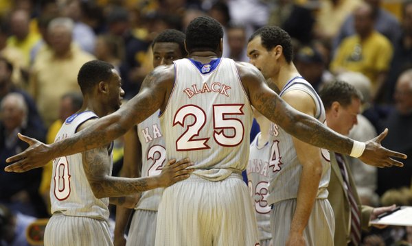 Kansas forward Tarik Black throws out his arms as the Jayhawks try to regroup in a huddle during a run by West Virginia in the second half on Saturday, March 8, 2014 at WVU Coliseum in Morgantown, West Virginia.