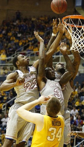 Kansas players Andrew Wiggins, left, Jamari Traylor and Tarik Black, go for a putback bucket over West Virginia forward Kevin Noreen during the second half on Saturday, March 8, 2014 at WVU Coliseum in Morgantown, West Virginia.