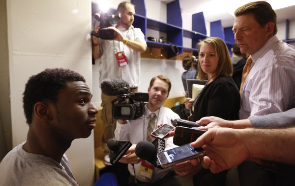 Kansas guard Andrew Wiggins grins as he answers questions from media members in the team locker room during a day of press conferences and practices at the Scottrade Center in St. Louis on Thursday, March 20, 2014.