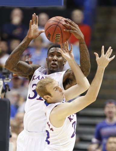 Kansas forward Jamari Traylor grabs a rebound over teammate Conner Frankamp during the second half on Friday, March 21, 2014 at Scottrade Center in St. Louis.