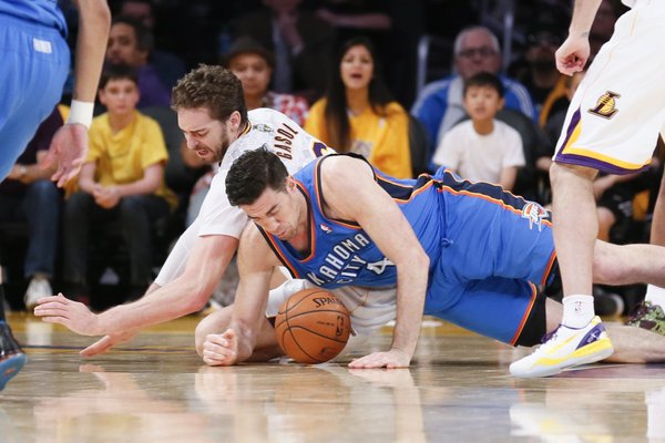 Los Angeles Lakers center Pau Gasol fights for a loose ball against Oklahoma City Thunder power forward Nick Collison during the second half of an NBA basketball game in Los Angeles, Sunday, March 9, 2014. The Lakers won 114-110. (AP Photo/Danny Moloshok)