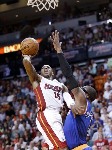Miami Heat guard Mario Chalmers (15) goes up for a shot against New York Knicks forward Amar'e Stoudemire (1) during the first half of an NBA basketball game, Sunday, April 6, 2014, in Miami. (AP Photo/Wilfredo Lee)