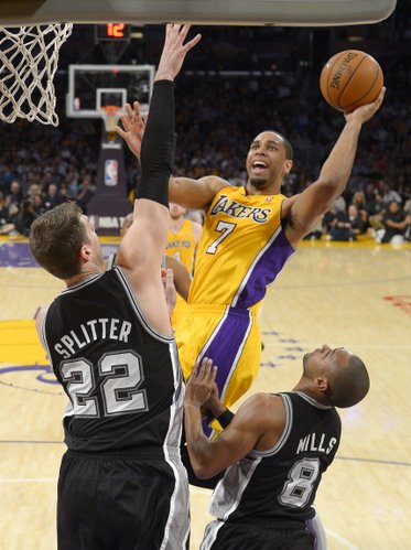Los Angeles Lakers forward Xavier Henry, right, puts up a shot as San Antonio Spurs center Tiago Splitter, left, of Brazil, and guard Patty Mills, of Australia, defend during the first half of an NBA basketball game, Wednesday, March 19, 2014, in Los Angeles. (AP Photo/Mark J. Terrill)