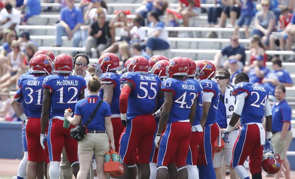 Blue Team coach John Reagan directs his players in the huddle during a break in the first half of the Kansas Spring Game on Saturday, April 12, 2014 at Memorial Stadium. Nick Krug/Journal-World Photo