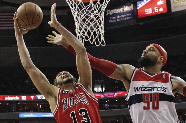 Chicago Bulls center Joakim Noah (13) shoots under pressure from Washington Wizards forward Drew Gooden (90) during the first half of Game 4 of an opening-round NBA basketball playoff series in Washington, Sunday, April 27, 2014. (AP Photo/Alex Brandon)
