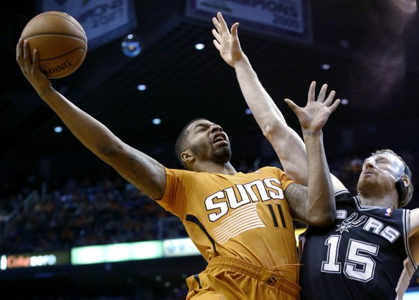 Phoenix Suns' Markieff Morris (11) tries to get off a shot over San Antonio Spurs' Matt Bonner (15) during the first half of an NBA basketball game, Friday, Feb. 21, 2014, in Phoenix. (AP Photo/Ross D. Franklin)