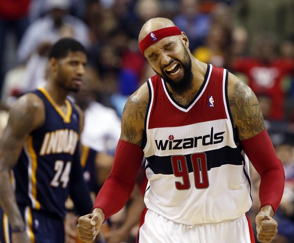 Washington Wizards forward Drew Gooden (90) celebrates after a play with Indiana Pacers forward Paul George (24) nearby in the second half of an NBA basketball game on Friday, March 28, 2014, in Washington. The Wizards won 91-78. (AP Photo/Alex Brandon)