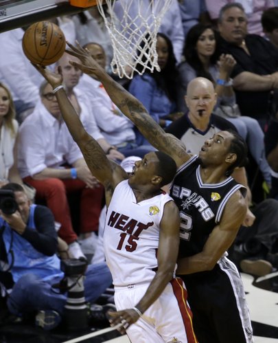 Miami Heat guard Mario Chalmers (15) goes to the basket as San Antonio Spurs forward Kawhi Leonard (2) defends in the first half in Game 4 of the NBA basketball finals, Thursday, June 12, 2014, in Miami. (AP Photo/Wilfredo Lee)
