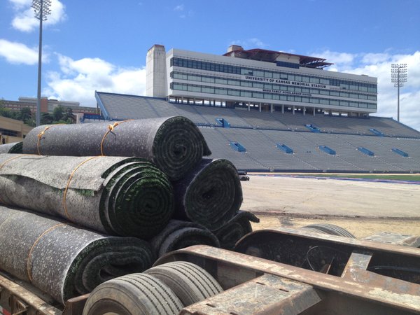 Rolls of new turf sit on a truck bed behind the south end zone at Memorial Stadium. 