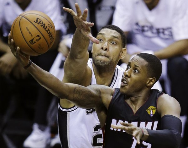 Miami Heat guard Mario Chalmers, right, shoots as San Antonio Spurs forward Tim Duncan defends during the second half in Game 2 of the NBA basketball finals on Sunday, June 8, 2014, in San Antonio. (AP Photo/Tony Gutierrez)