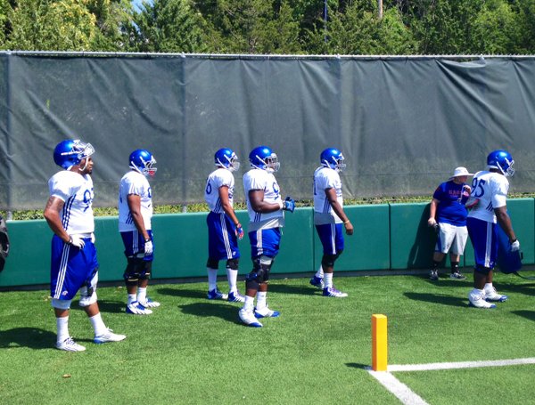 Several KU defensive linemen wait for their turn in a drill at Monday's practice. 
