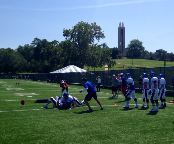 Kyron Watson takes down Brandon Bourbon during a one-on-one LB vs. RB drill on Thursday. Notice the ball bouncing on the turf to the left of the pile of bodies as well as how intense RB coach Reggie Mitchell (red) and LB coach Clint Bowen (blue) are during the drill. 