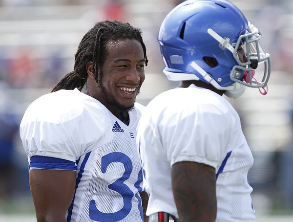 Kansas safety Tevin Shaw, left, laughs with a teammate during Fan Appreciation Day, Saturday, Aug. 16, 2014 at Memorial Stadium.