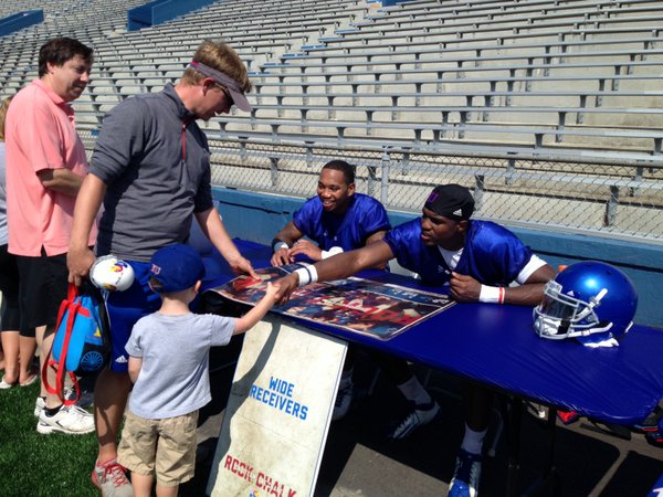 KU receivers Nick Harwell (left) and Justin McCay meet a young fan in the autograph line after the practice. 