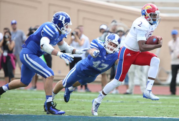 Kansas quarterback Montell Cozart is tailed by Duke defenders Kyler Brown (56) and David Helton (47) during the first quarter on Saturday, Sept. 13, 2013 at Wallace Wade Stadium in Durham, North Carolina.