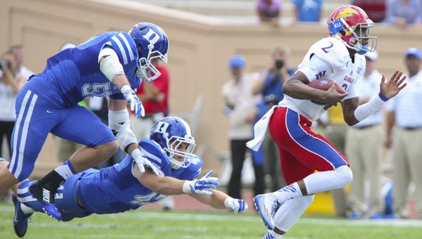 Duke defenders Kyler Brown (56) and David Helton (47) stay hot on the trail of Kansas quarterback Montell Cozart during the first quarter on Saturday, Sept. 13, 2013 at Wallace Wade Stadium in Durham, North Carolina.