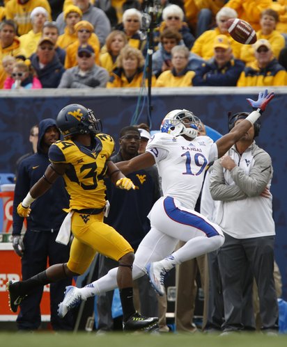 A deep pass to Kansas receiver Justin McCay goes long as he is trailed by West Virginia cornerback Ishmael Banks during the first quarter on Saturday, Oct. 4, 2014 at Milan Puskar Stadium in Morgantown, West Virginia.