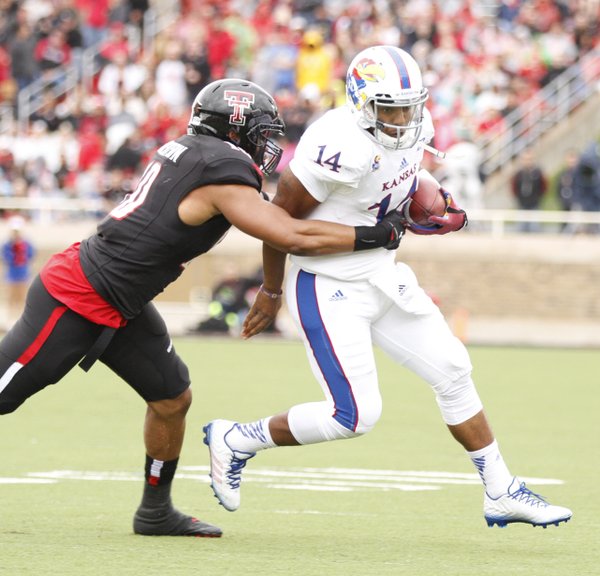 Kansas quarterback Michael Cummings is chased down by Texas Tech linebacker Pete Robertson during the first quarter on Saturday, Oct. 18, 2014 at Jones AT&T Stadium in Lubbock, Texas.