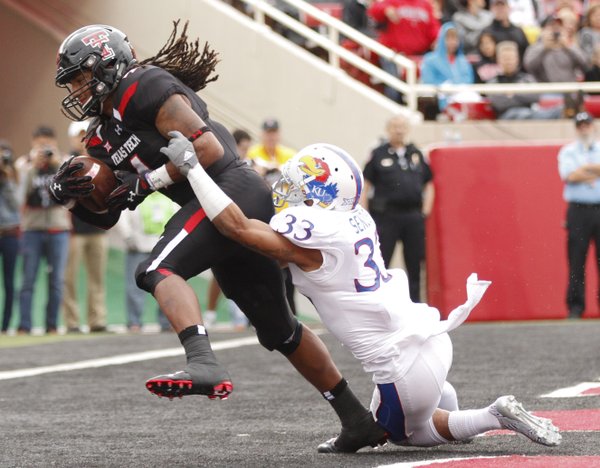 Texas Tech receiver Bradley Marquez pulls in a touchdown pass against Kansas safety Cassius Sendish during the second quarter on Saturday, Oct. 18, 2014 at Jones AT&T Stadium in Lubbock, Texas.