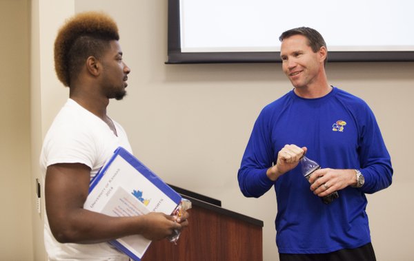 Kansas interim head football coach Clint Bowen chats with running back Corey Avery after a meeting with the whole team in Mrkonic Auditorium on Wednesday, Oct. 22, 2014.