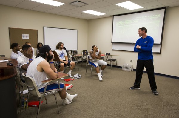 Kansas head football coach Clint Bowen laughs with the linebackers and bucks during a breakout session on Wednesday, Oct. 22, 2014.