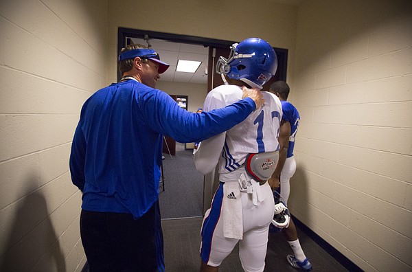 Kansas head football coach Clint Bowen chats up receiver Darious Crawley while leaving the locker room for practice on Wednesday, Oct. 22, 2014.
