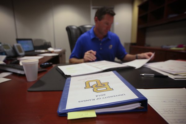 The scouting report for Baylor sits at the top of Kansas head football coach Clint Bowen's desk as he sits down at his desk on Wednesday, Oct. 22, 2014.