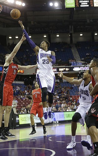 Sacramento Kings guard Ben McLemore, right, drives to the basket against Toronto Raptors forward Tyler Hansbrough, left, during the fourth quarter of an NBA preseason basketball game in Sacramento, Calif., Tuesday, Oct. 7, 2014. The Kings won 113-106. (AP Photo/Rich Pedroncelli)
