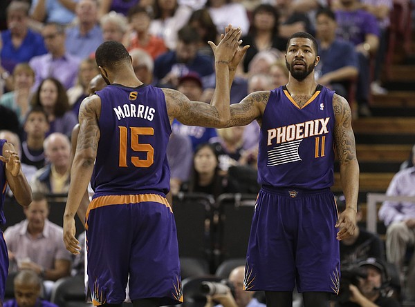 Phoenix Suns forward Marcus Morris, left, congratulates his twin brother, Markieff, after he scored against the Sacramento Kings during the fourth quarter of an NBA basketball game in Sacramento, Calif., Wednesday, April 16, 2014. The Suns won 104-99.(AP Photo/Rich Pedroncelli)
