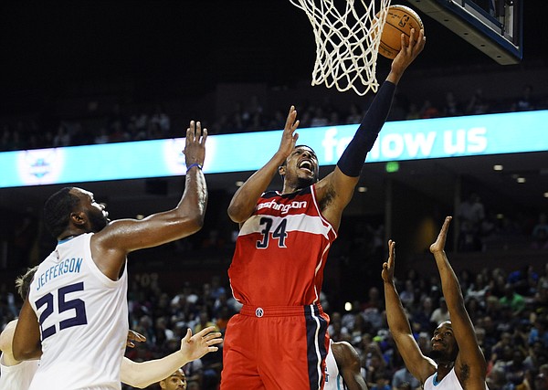 Washington Wizards forward Paul Pierce (34) looks to score as Charlotte Hornets center Al Jefferson (25) and Charlotte Hornets guard Kemba Walker (15) defend during the first half of a preseason NBA basketball game, Friday, Oct. 10, 2014, in Greenville, S.C. (AP Photo/Rainier Ehrhardt)
